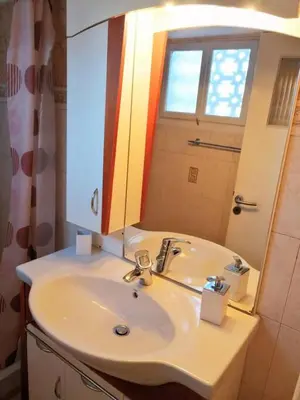 a bathroom with a white sink and a mirror at Cozy apartment in Acropolis with roof garden in Athens