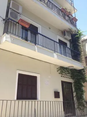 a white building with a balcony and a fence at Cozy apartment in Acropolis with roof garden in Athens