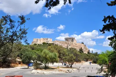 a view of the acropolis of athens from a street with trees at Cozy apartment in Acropolis with roof garden in Athens