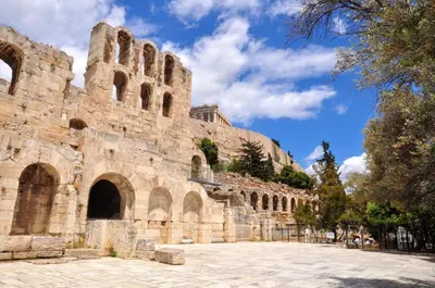 a large stone building with a blue sky in the background at Cozy apartment in Acropolis with roof garden in Athens