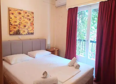 a bedroom with a white bed and a window at Cozy apartment in Acropolis with roof garden in Athens