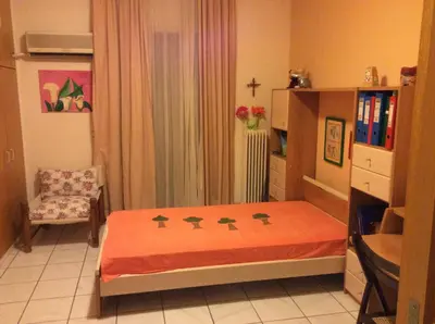a small bedroom with a bed and a chair at Filyra Homestay (Όμορφο δωμάτιο σε σπίτι) in Athens