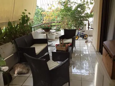 a patio with chairs and a cat laying on a tile floor at Filyra Homestay (Όμορφο δωμάτιο σε σπίτι) in Athens