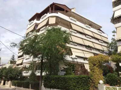 a building with a tree in front of it at Filyra Homestay (Όμορφο δωμάτιο σε σπίτι) in Athens