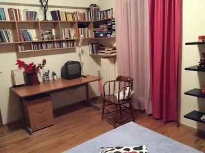 a desk and chair in a room with book shelves at Filyra Homestay (Όμορφο δωμάτιο σε σπίτι) in Athens