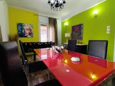 a dining room with a red table and green walls at Stunning apartment in the heart of Athens in Athens