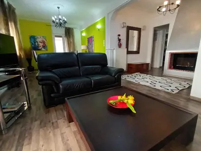 a living room with a black leather couch and a table at Stunning apartment in the heart of Athens in Athens