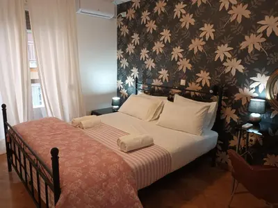a bedroom with a bed with a floral wallpaper at Stunning apartment in the heart of Athens in Athens