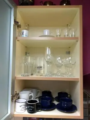a cupboard filled with glasses and other glass items at Stunning apartment in the heart of Athens in Athens