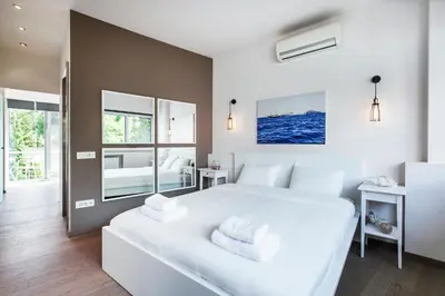 a white bedroom with a large white bed and mirror at K5 - Walk into Heritage in Athens