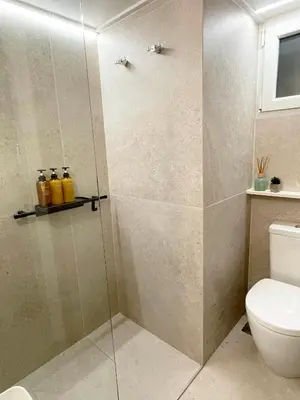 a shower with a glass door in a bathroom at The CucuWow in Athens