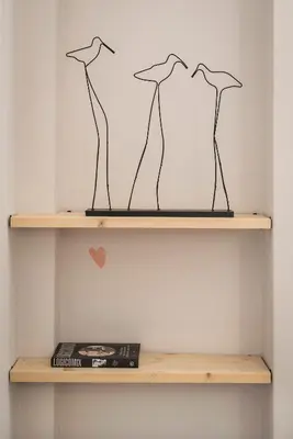 a shelf with three drawings of three birds at The CucuWow in Athens