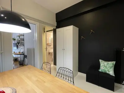 a dining room with a table and a black wall at The CucuWow in Athens