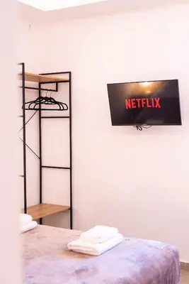 a room with a bed with a netflix sign on the wall at Stone Palace Hotel Near Athen's Airport Free Shuttle From and to Athen's Airport in Spáta