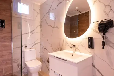 a bathroom with a toilet and a sink and a mirror at Stone Palace Hotel Near Athen's Airport Free Shuttle From and to Athen's Airport in Spáta