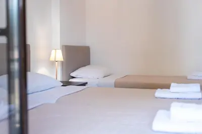 a hotel room with two beds and a lamp at Stone Palace Hotel Near Athen's Airport Free Shuttle From and to Athen's Airport in Spáta