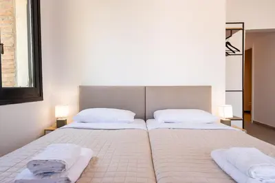 a bedroom with two beds with towels on them at Stone Palace Hotel Near Athen's Airport Free Shuttle From and to Athen's Airport in Spáta