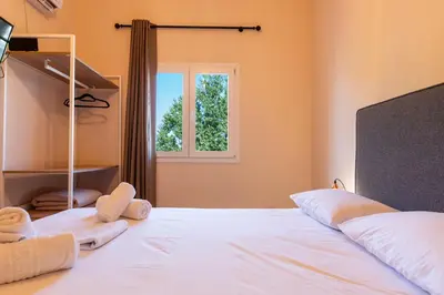 a bedroom with a large bed and a window at Stone Palace Hotel Near Athen's Airport Free Shuttle From and to Athen's Airport in Spáta