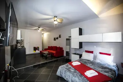 a bedroom with a red bed and a red couch at Trendy Living in Monastiraki in Athens