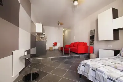 a bedroom with a bed and a red couch at Trendy Living in Monastiraki in Athens