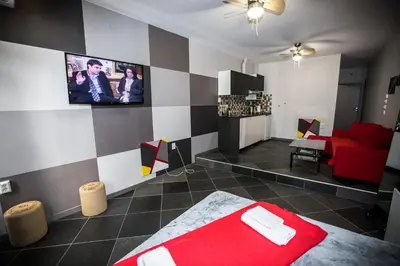 a bedroom with a red bed and a tv on the wall at Trendy Living in Monastiraki in Athens