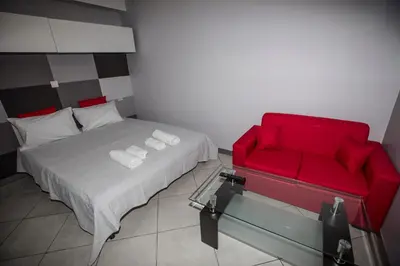 a bedroom with a red bed and a red chair at Trendy Living in Monastiraki in Athens