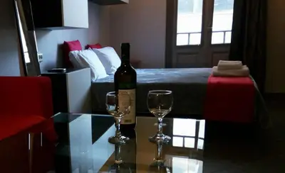 a room with a bottle of wine and two glasses on a table at Trendy Living in Monastiraki in Athens
