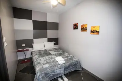 a small bedroom with a bed and two pictures on the wall at Trendy Living in Monastiraki in Athens
