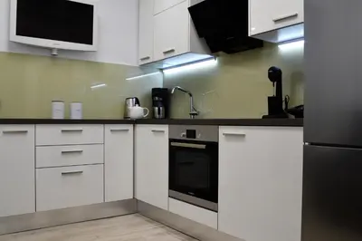 a kitchen with white cabinets and a black appliance at Athens Nest in Athens