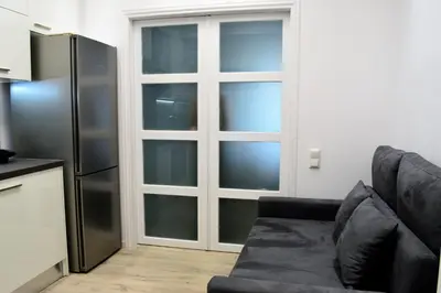 a living room with a couch and a refrigerator at Athens Nest in Athens