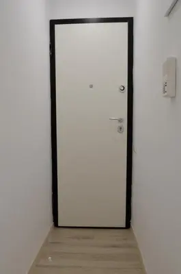 a white door in a room with a wooden floor at Athens Nest in Athens