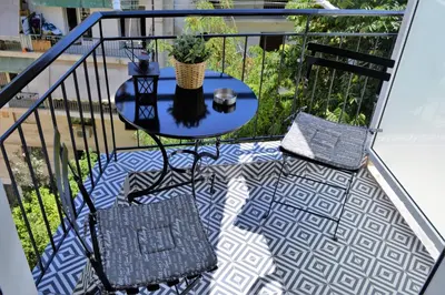 a patio with a table and chairs on a balcony at Athens Nest in Athens