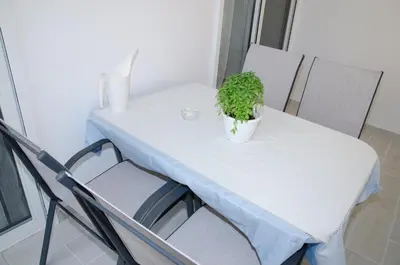 a white table with a potted plant on it at Holiday Apartment Glyfada in Athens