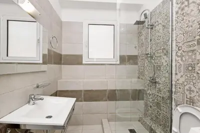 a bathroom with a sink and a shower at Holiday Apartment Glyfada in Athens