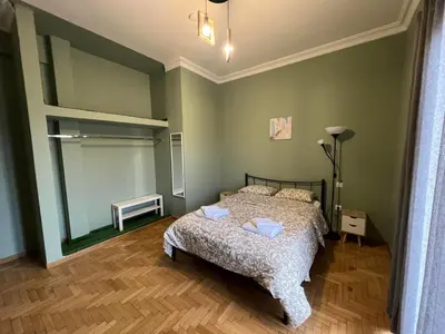 a bedroom with a bed in a room with green walls at Sfiggos 54 Guest House in Athens