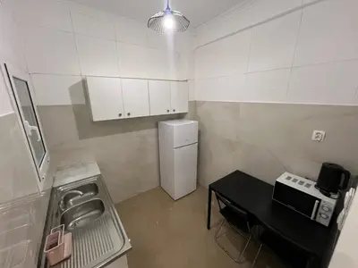 a small kitchen with a sink and a refrigerator at Sfiggos 54 Guest House in Athens