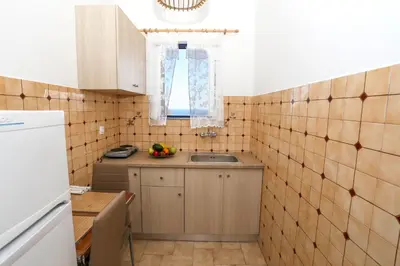 a small kitchen with a sink and a window at Yiannis Studios in Agia Marina Aegina