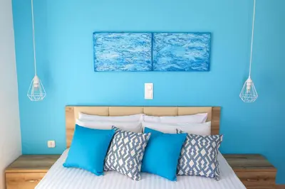 a blue bedroom with a bed with blue walls at Yiannis Studios in Agia Marina Aegina
