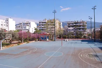 an empty basketball court in a city with buildings at Luxurious Loft with Garden in Athens