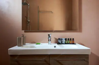 a white sink in a bathroom with a mirror at Elaia Luxury Suites Lagonisi in Lagonissi