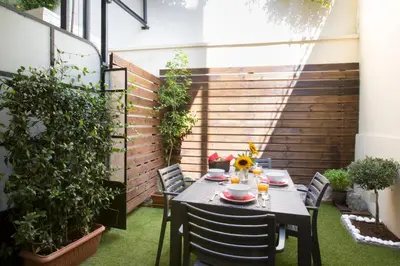 a patio with a table and chairs on the grass at Under the shade of Acropolis by YHA in Athens