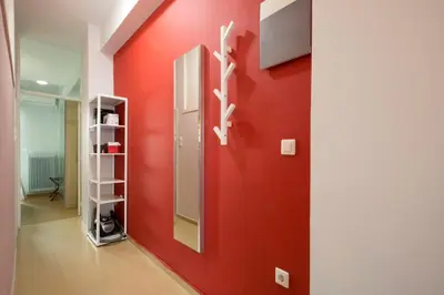 a red wall with a mirror in a hallway at Under the shade of Acropolis by YHA in Athens