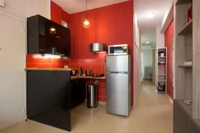 a kitchen with red walls and a refrigerator at Under the shade of Acropolis by YHA in Athens