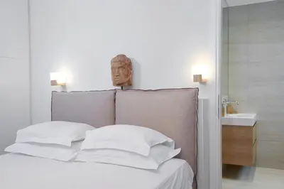a bedroom with a bed with white pillows and a sink at Lux Central Apt at Kolonaki Area in Athens