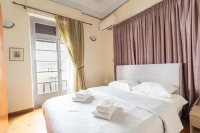 a bedroom with a large white bed with towels on it at Ideal 4 bdr Apartment in Plaka for 10! in Athens