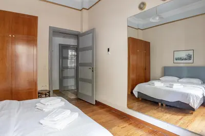 a bedroom with two beds and a large mirror at Ideal 4 bdr Apartment in Plaka for 10! in Athens