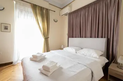 a bedroom with a white bed with towels on it at Ideal 4 bdr Apartment in Plaka for 10! in Athens