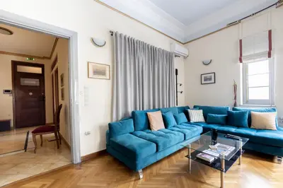 a living room with a blue couch and a table at Ideal 4 bdr Apartment in Plaka for 10! in Athens