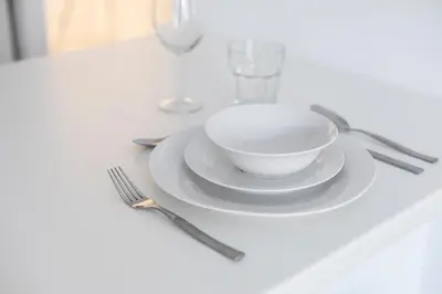 a white plate with a bowl and a fork on a table at Euryclea Residences in Athens