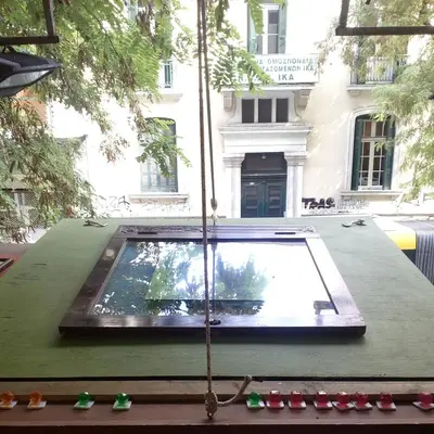 a table with a pool of water in front of a building at Athens centre diamond in Athens